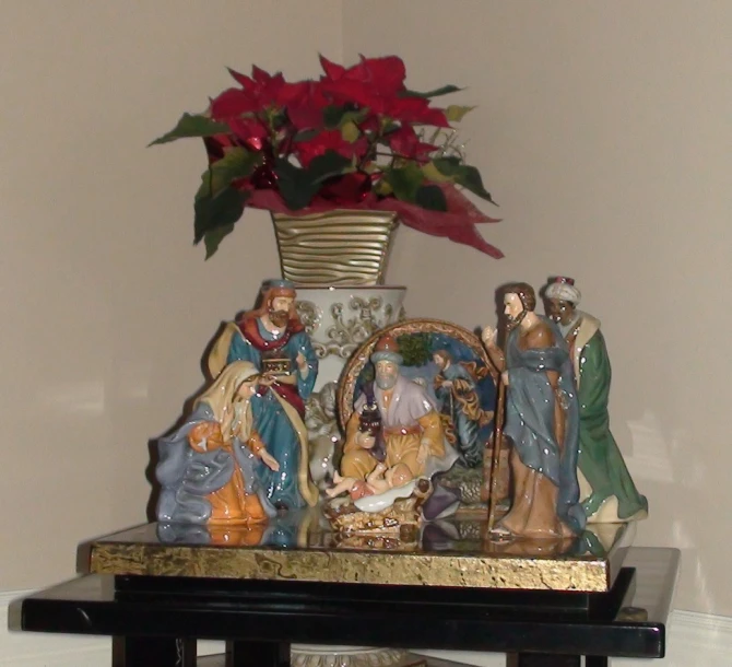 a collection of christmas figurines with a large red flower