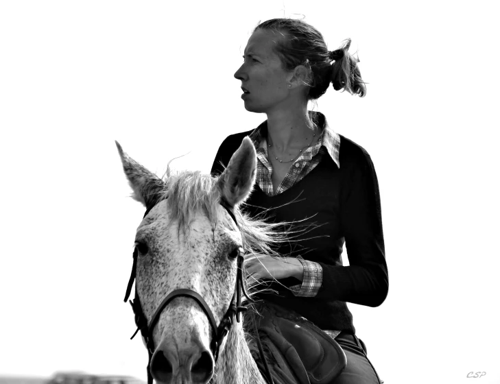 a woman in uniform riding a horse on the beach