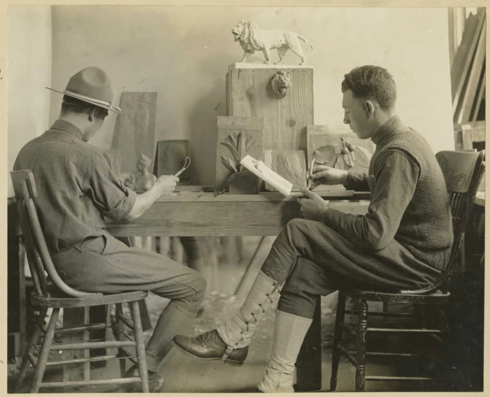 two people sitting at a table reading books