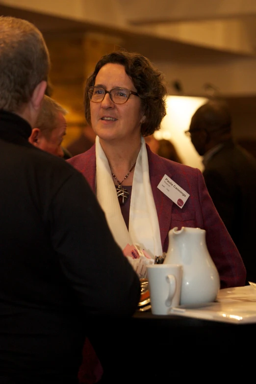 a woman sitting next to a vase with a scarf around her neck