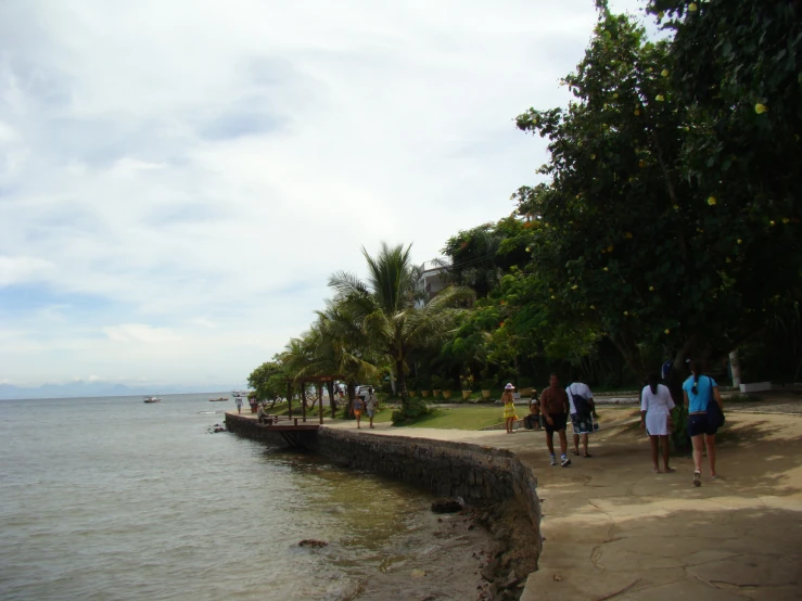 people walk along the shoreline to the beach