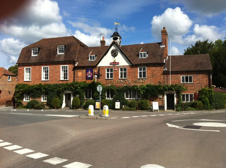 an empty street and building next to some hedges