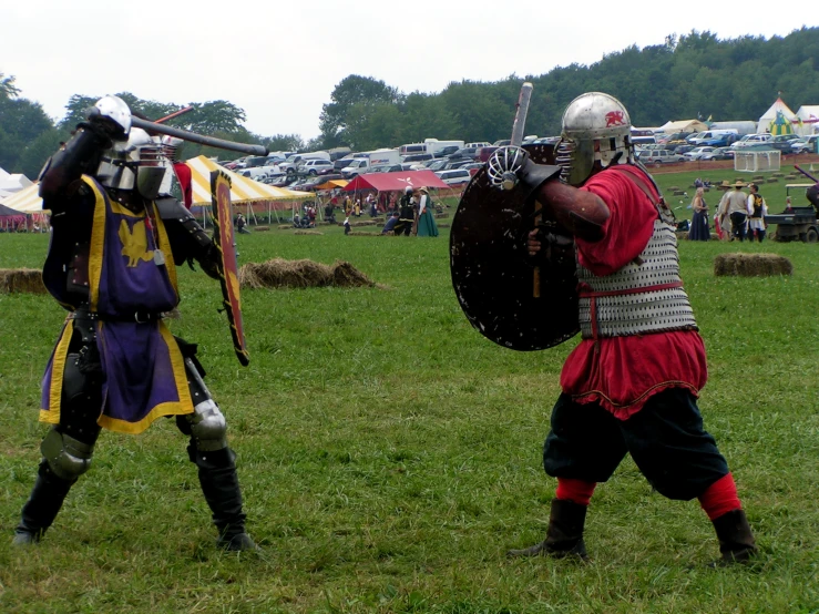 two men in medieval garb playing a game with a sword