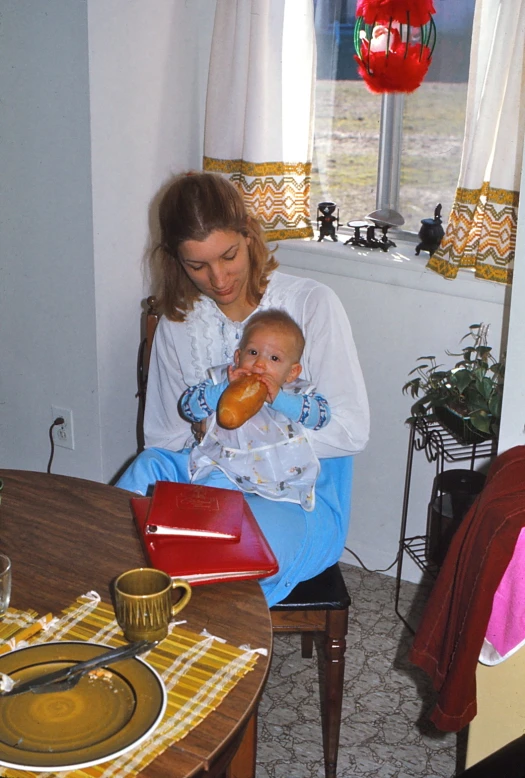 a woman sitting down and holding a small child in her arms