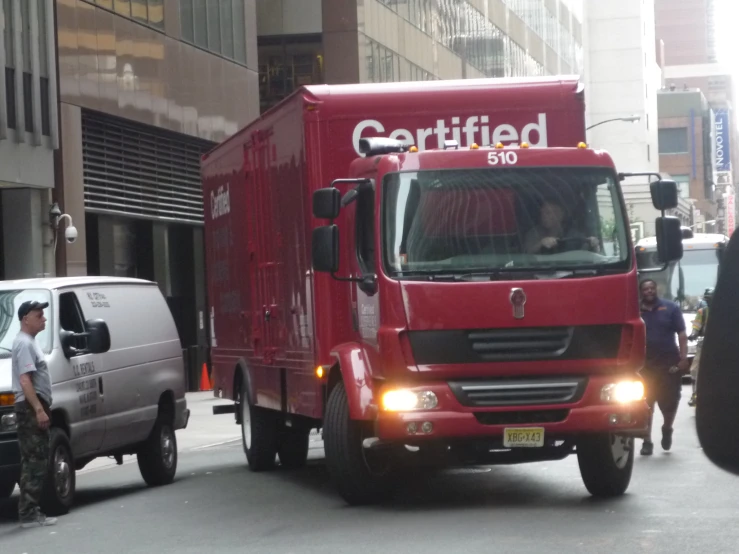 a red truck driving down a busy city street