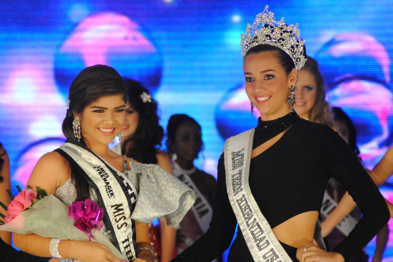 two women are holding the same sash for each other