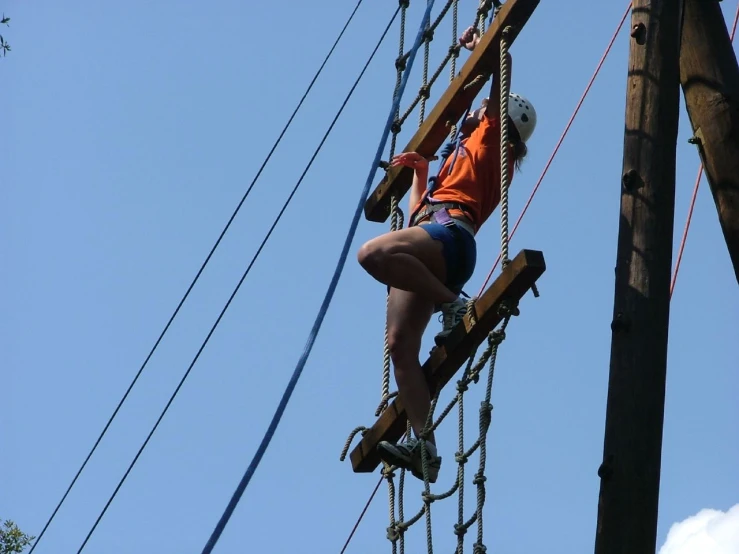 a man who is climbing a rope near a pole