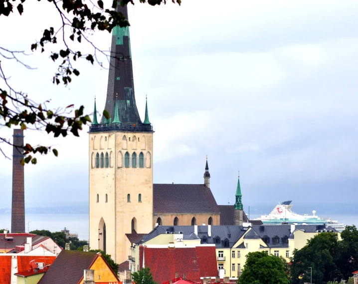 an old city with a steeple on top and two chimneys