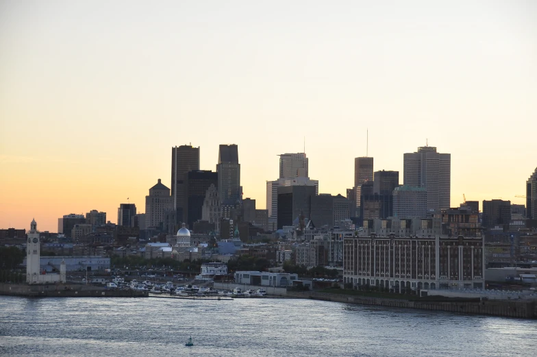 a view of the skyline from across the river at sunset