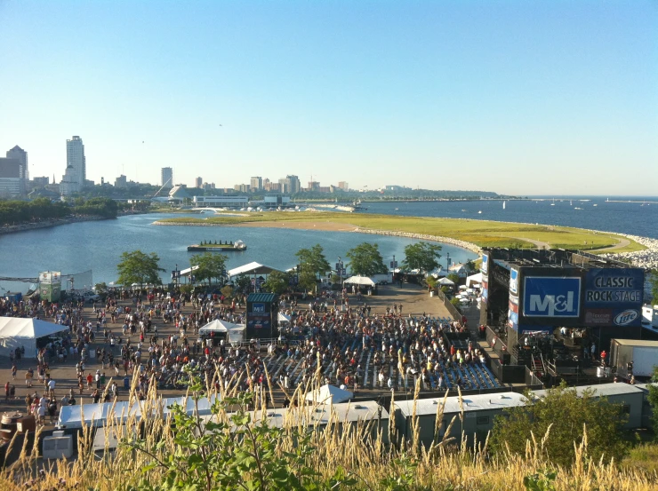 a large crowd gathering around in front of a river