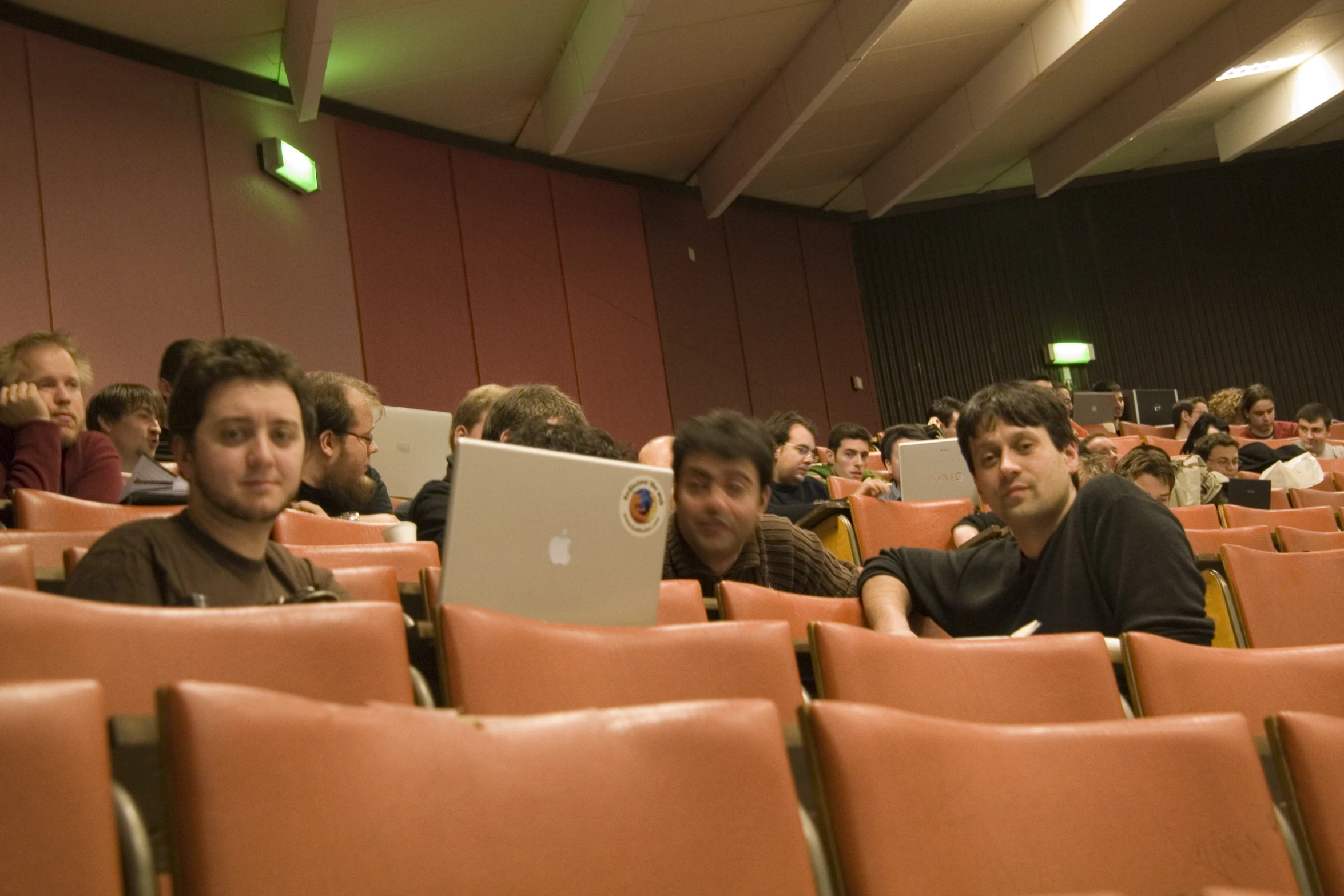 a group of people sitting in a auditorium together