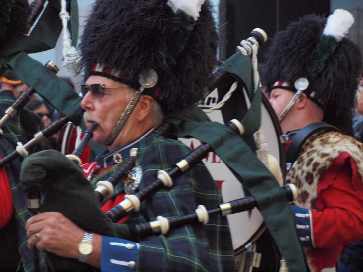 a group of men wearing kilts marching down the street