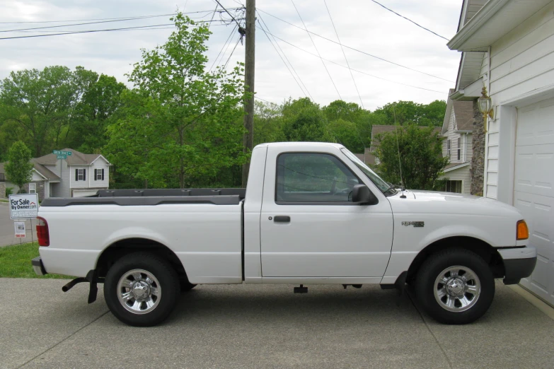 white truck parked in driveway with a house behind it