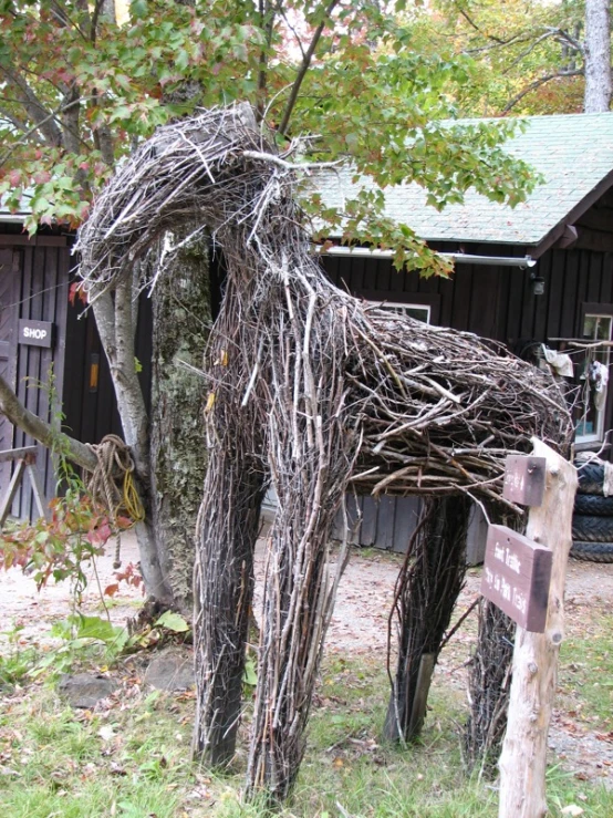 a horse made from vines in front of a building