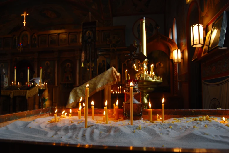 candles lit in a small, wooden church