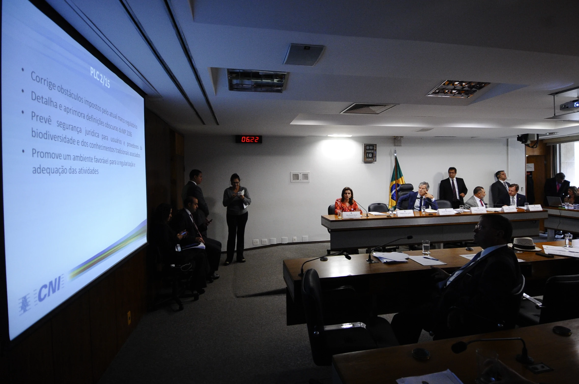 a group of people standing and sitting around a conference room