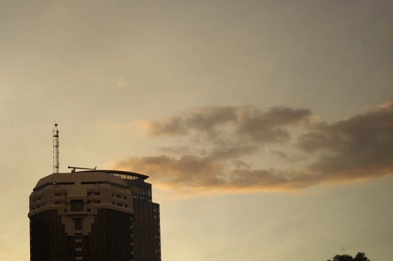 a tall building under a cloudy sky with a antennas