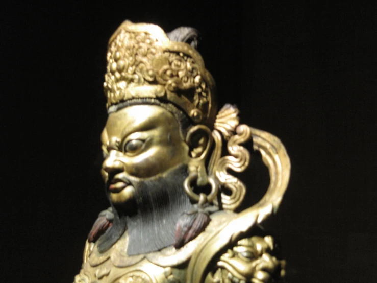 a decorative figurine of an asian king, possibly a buddhist monk or god