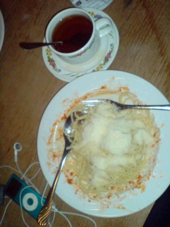 a plate of food and a cup of tea on a wooden table