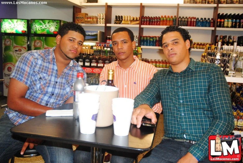 two men in a store, one holding a bottle and the other looking at camera