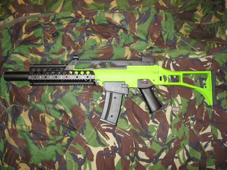 a green and black machine gun on camouflage background