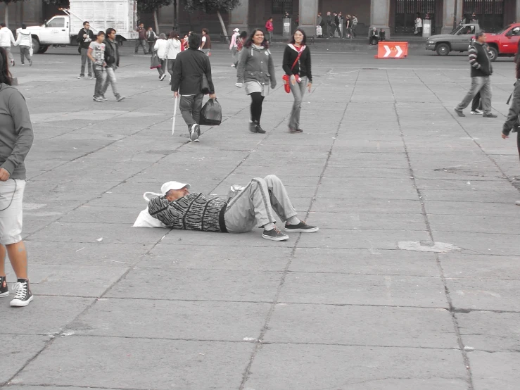 a person laying on the ground next to a group of people