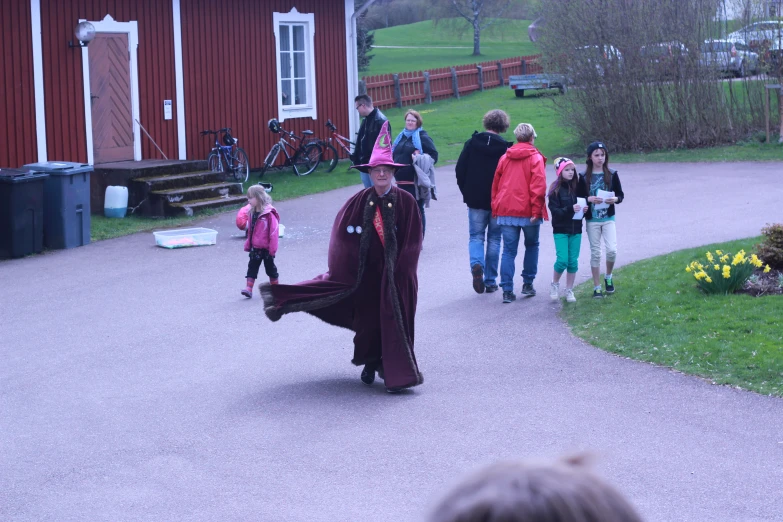 children are being guided down a path wearing costume