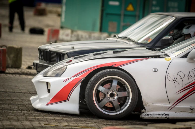 the front end of a sports car painted in red and white