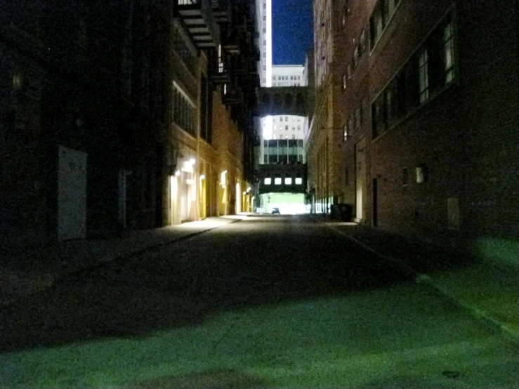 a alley is shown at night lit by buildings