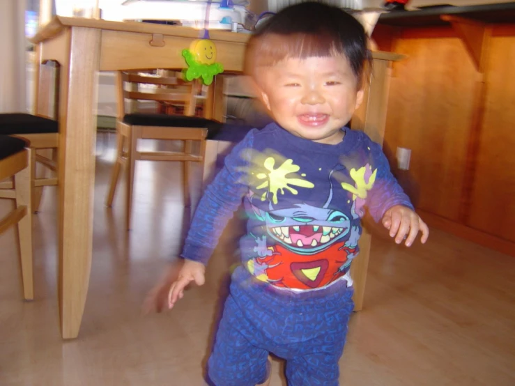 small toddler in pajamas walking through kitchen floor