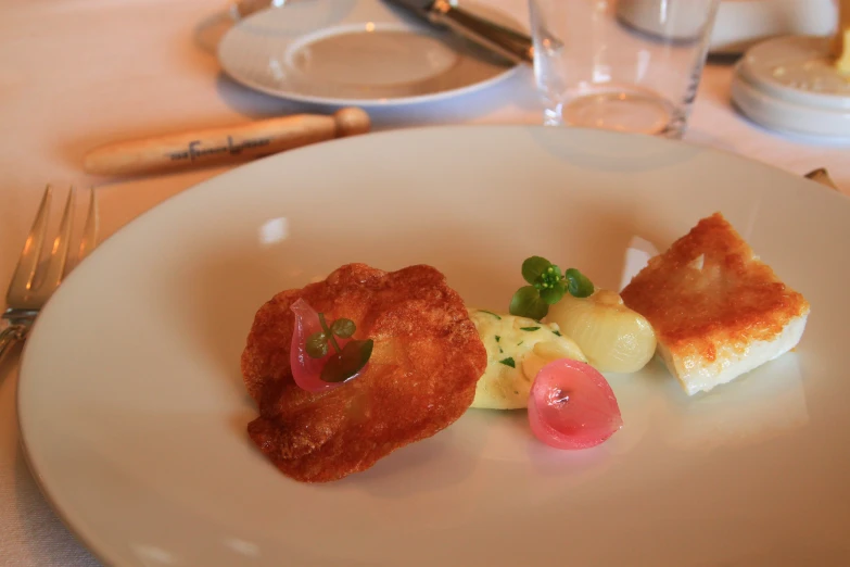 some food sits on top of a white plate