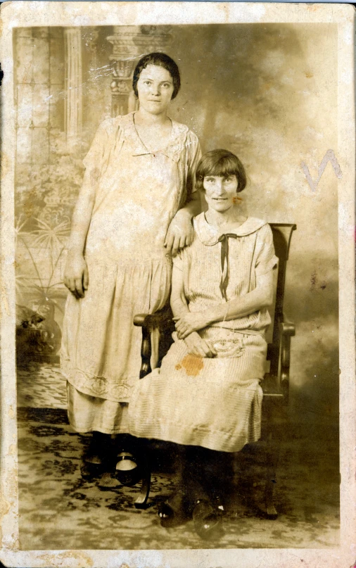 an old time picture of two women sitting next to each other