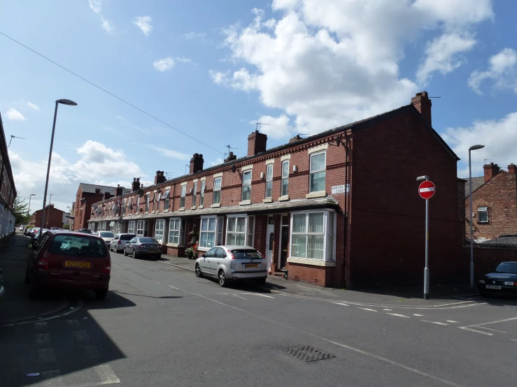 cars and motor cycles are parked in front of buildings