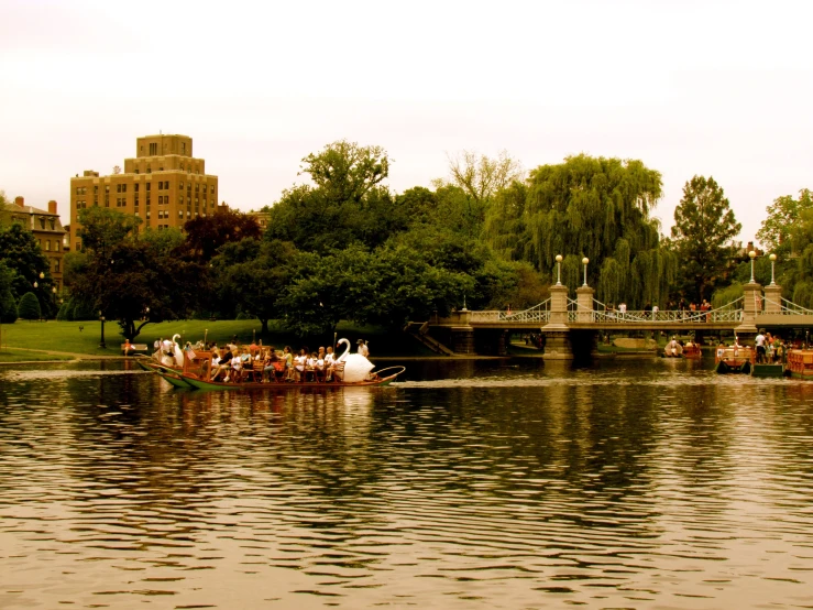 a group of people ride boats across a pond