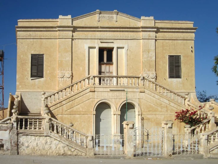 the front view of an old building with stairs and steps