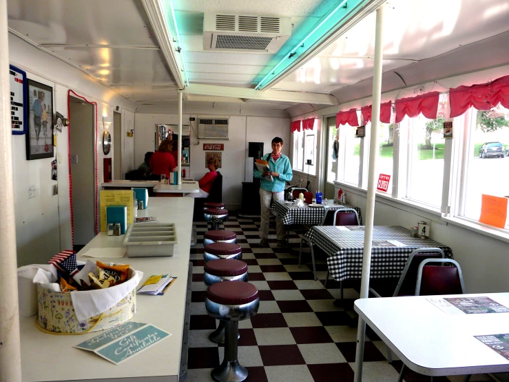diners line the inside of a diner with checkered walls