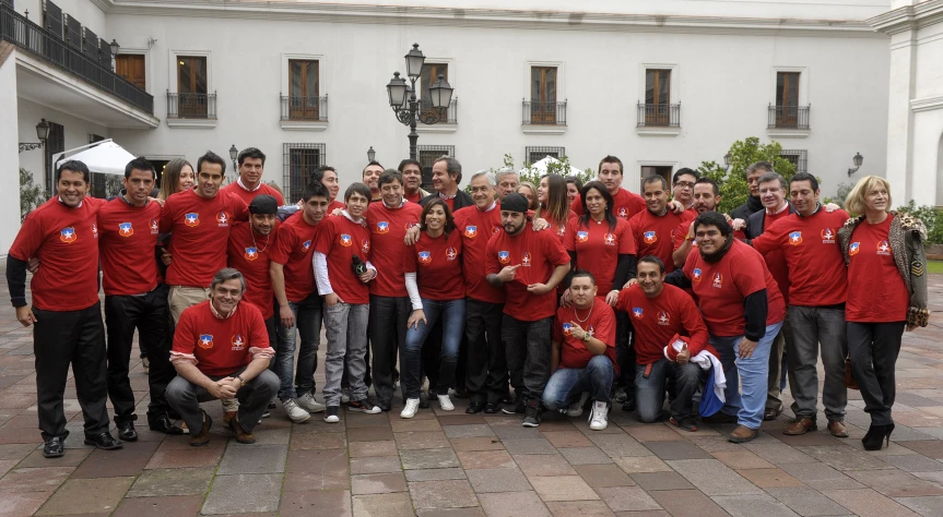 a group of people in red shirts posing for the camera