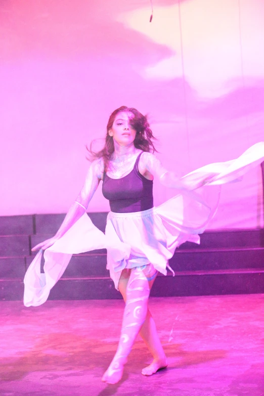 a woman dancing in a pink lit area