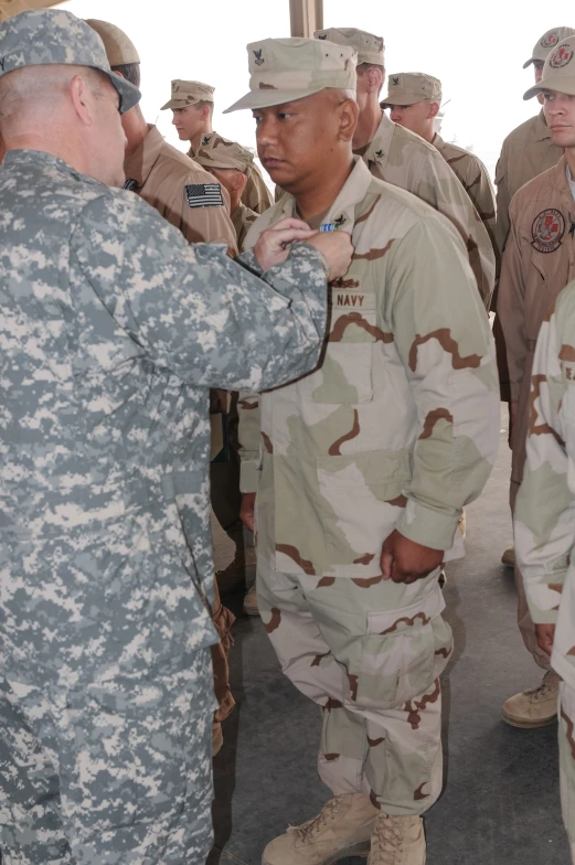 two men in military uniforms greeting one another