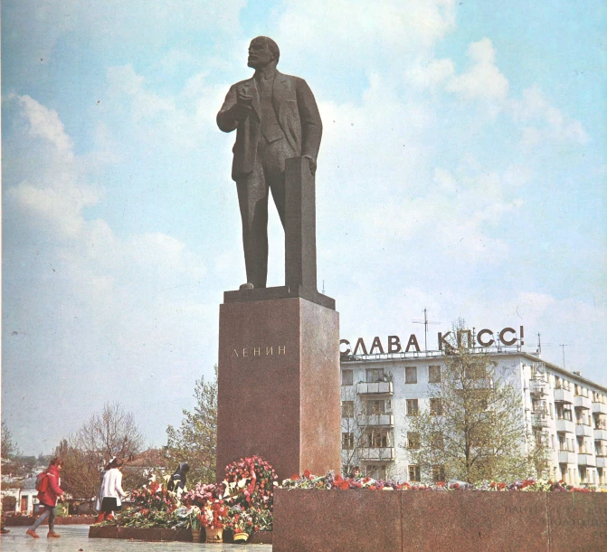 a man in business attire sitting on the top of a statue