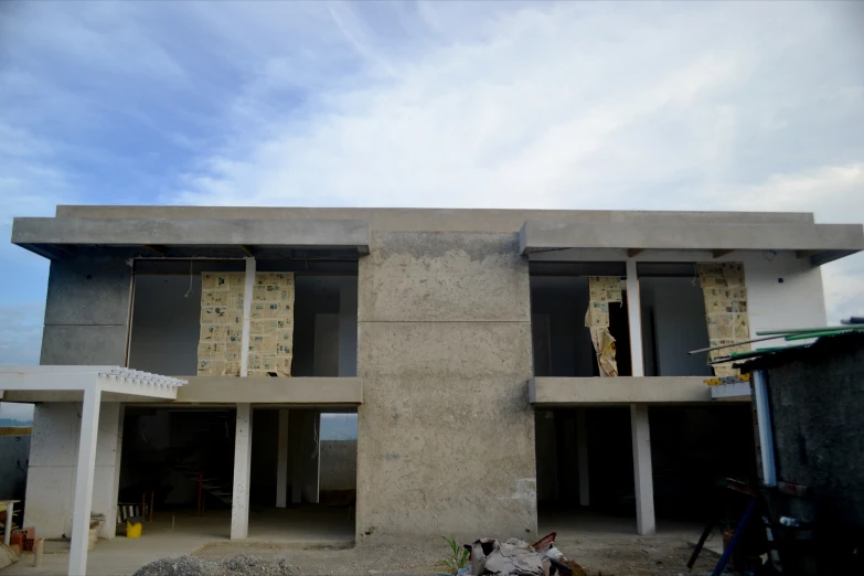 an unfinished building has multiple windows and a roof