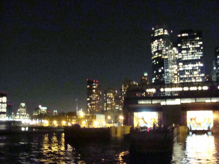 boats out in the river at night with city lights on