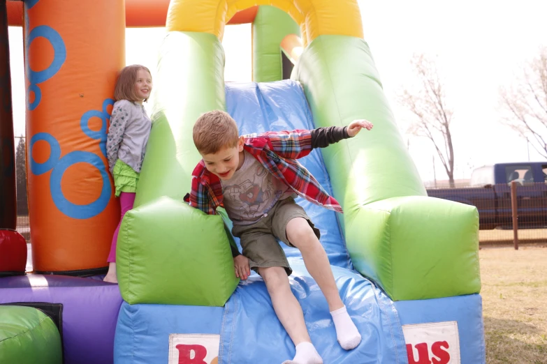 a little boy on top of a slide