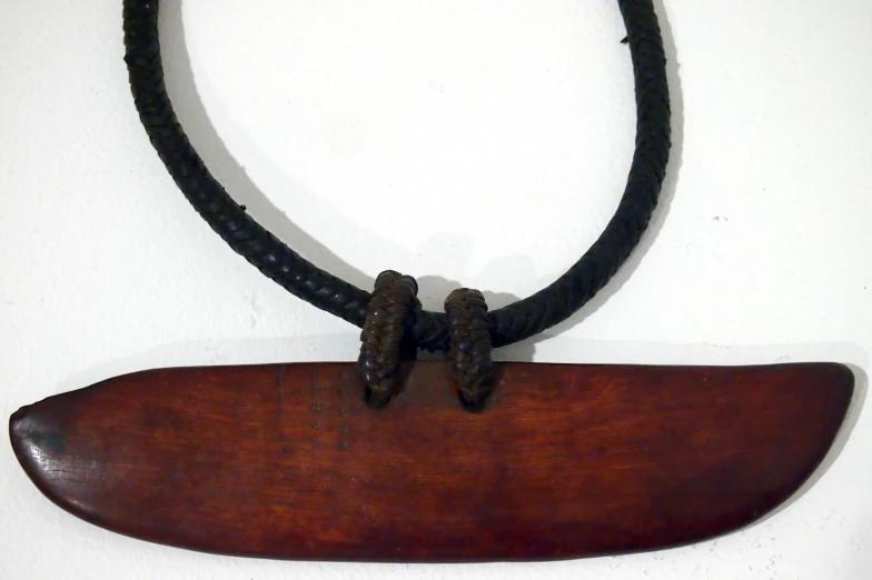 a long wooden piece hanging on a rope with two strings