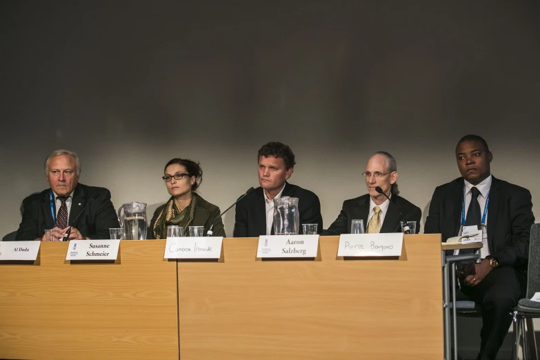 several people at a conference with signs on the table