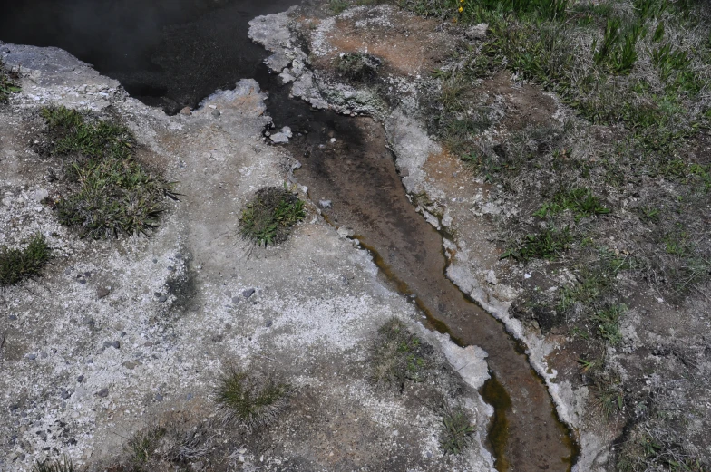 looking down on a snow covered ground and a small stream