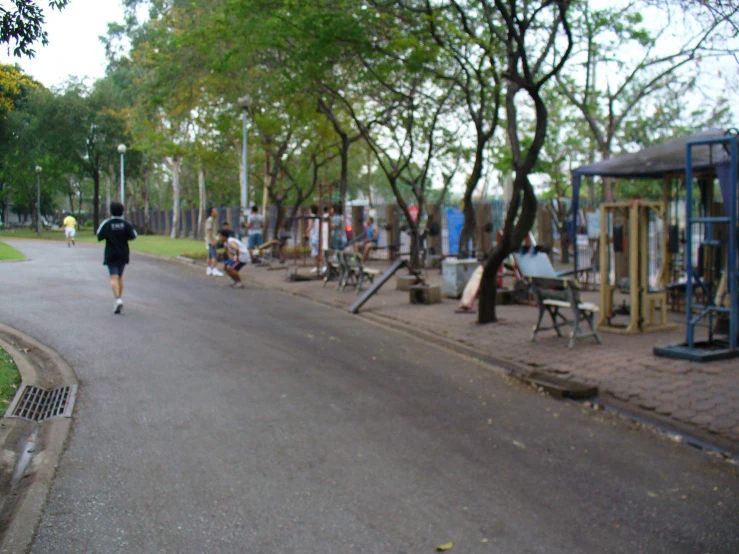 a man running down a path by some playground equipment