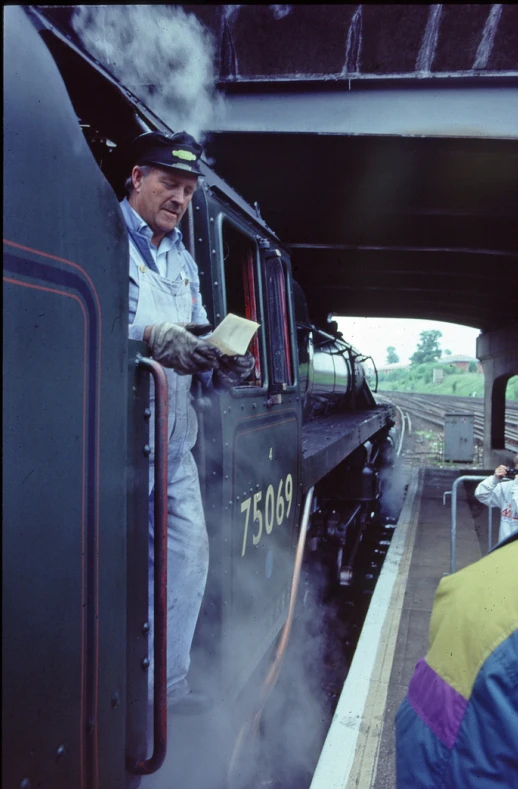 a man with his hand on the door of a train