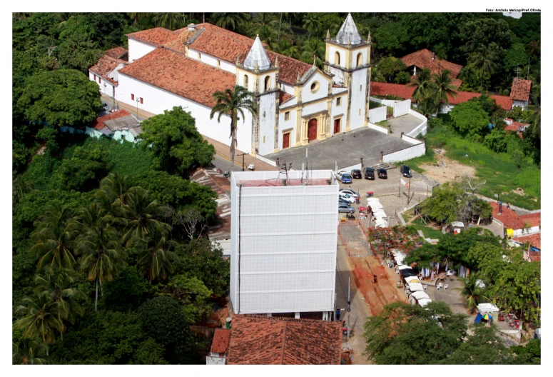 an aerial po of a church with many trees around it