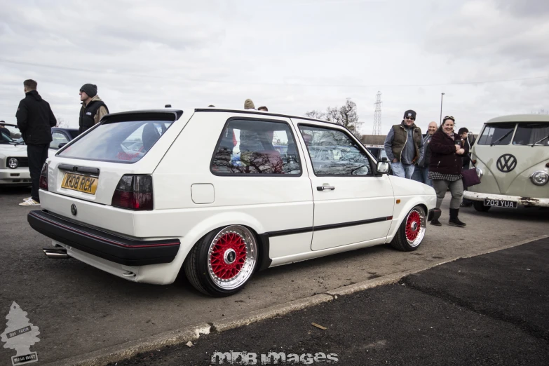 this small car is white and has red rims